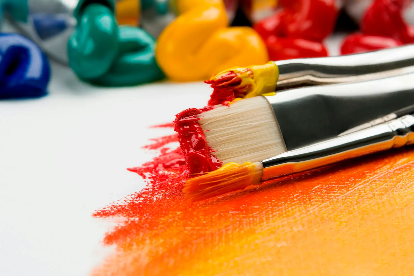 paint brushes and tubes of acrylic paint on an artist’s work table